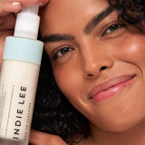Woman holding Bottle of Indie Lee CoQ-10 Cleanser