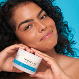 Woman holding Jar of Indie Lee Coconut Citrus Body Scrub