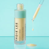 Bottle of Indie Lee Vitamin C Serum with applicator dripping product