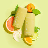 2 Tubes of Indie Lee Energize Deodorant on a light green background