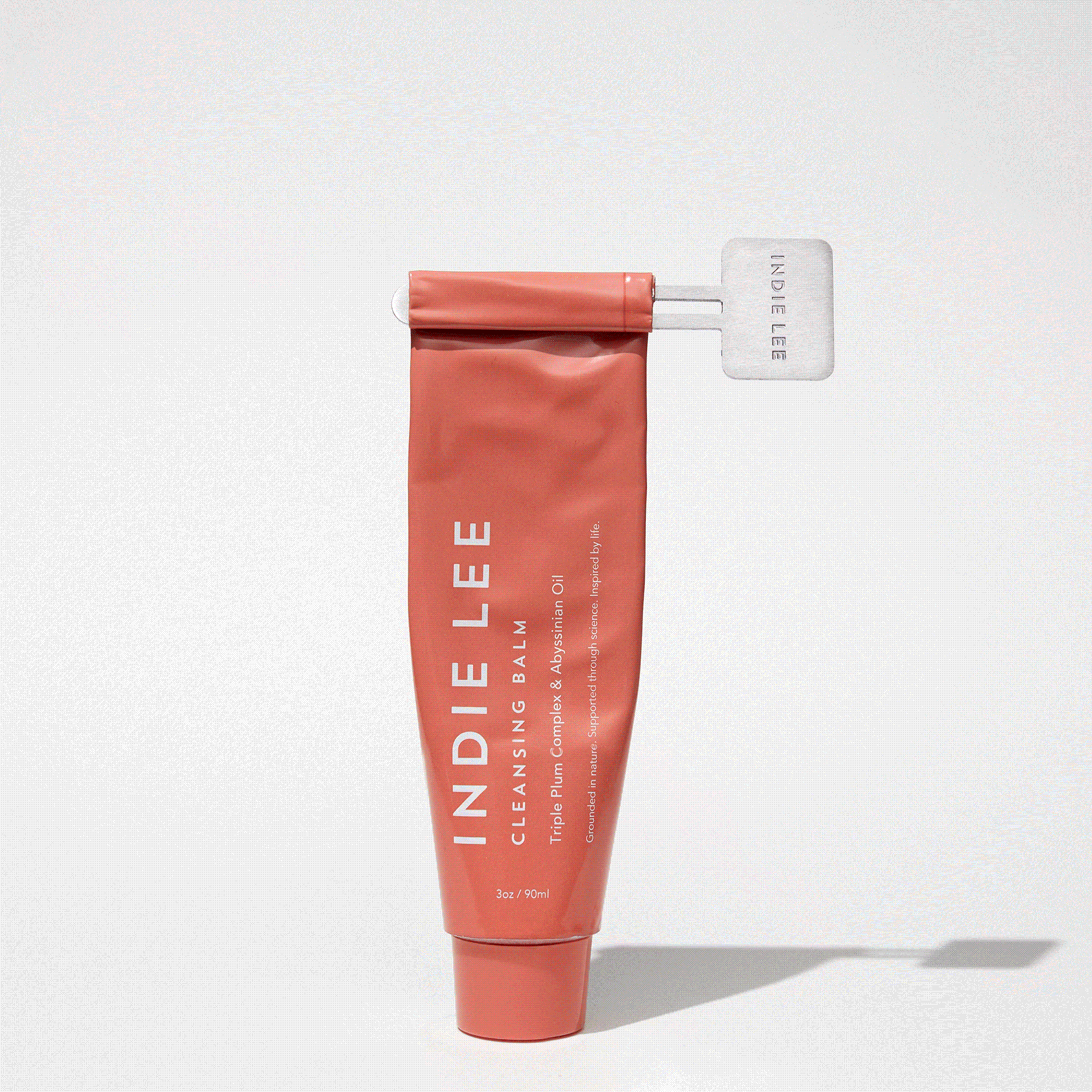 Tube of Indie Lee Cleansing Balm being dispensed