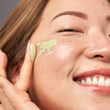 Woman applying Indie Lee Color Balancer to her face