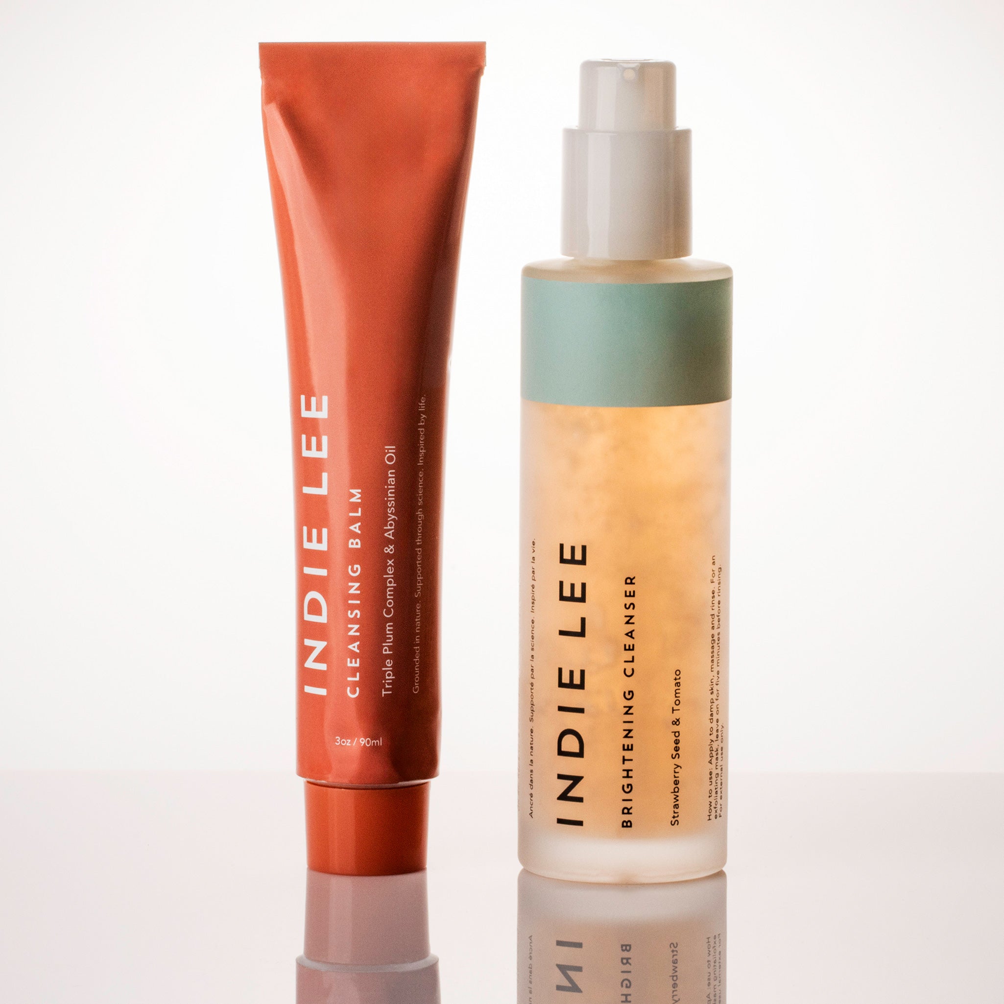 Indie Lee cleansing balm and brightening cleanser on a white background