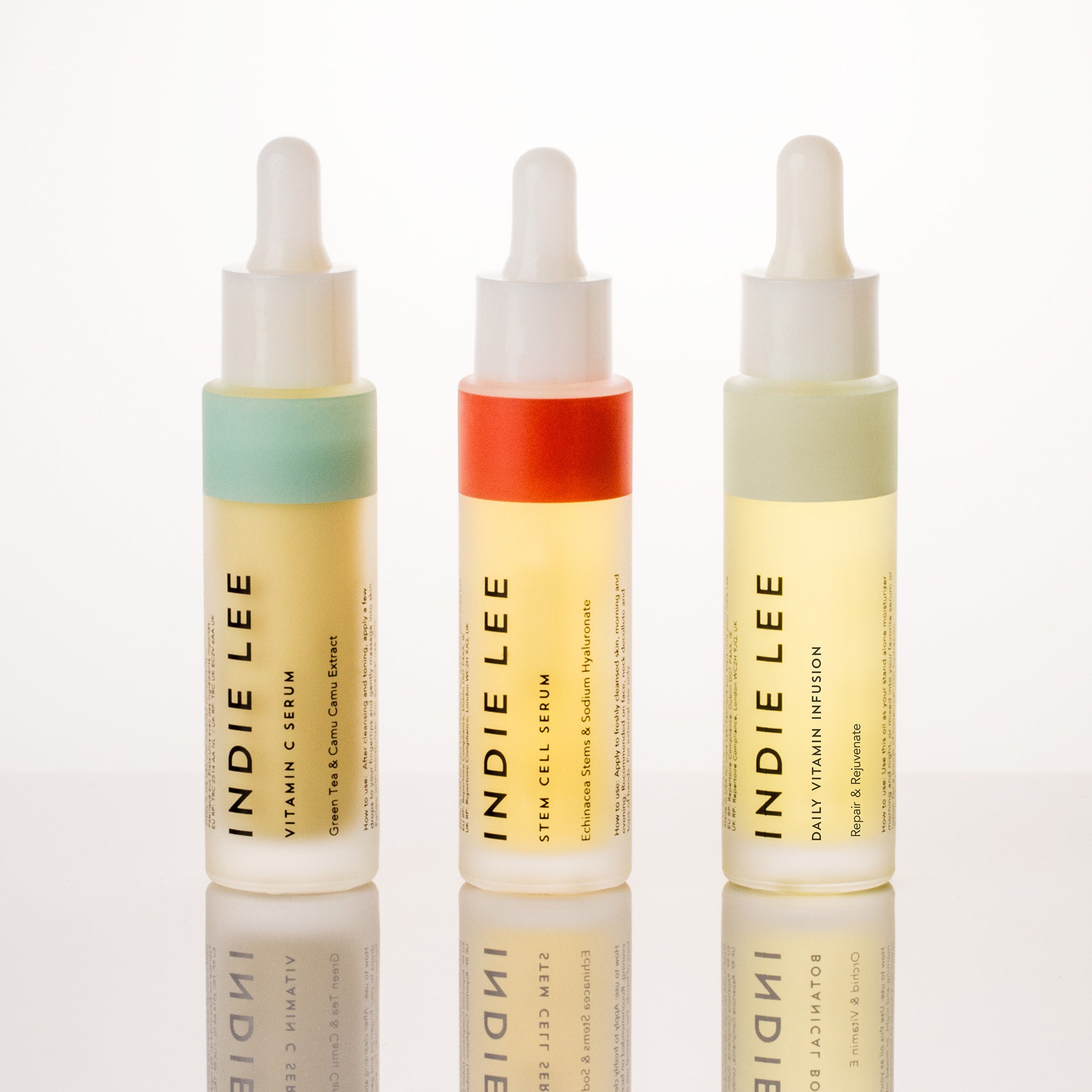 Three bottles of Indie Lee skincare serum on a white background