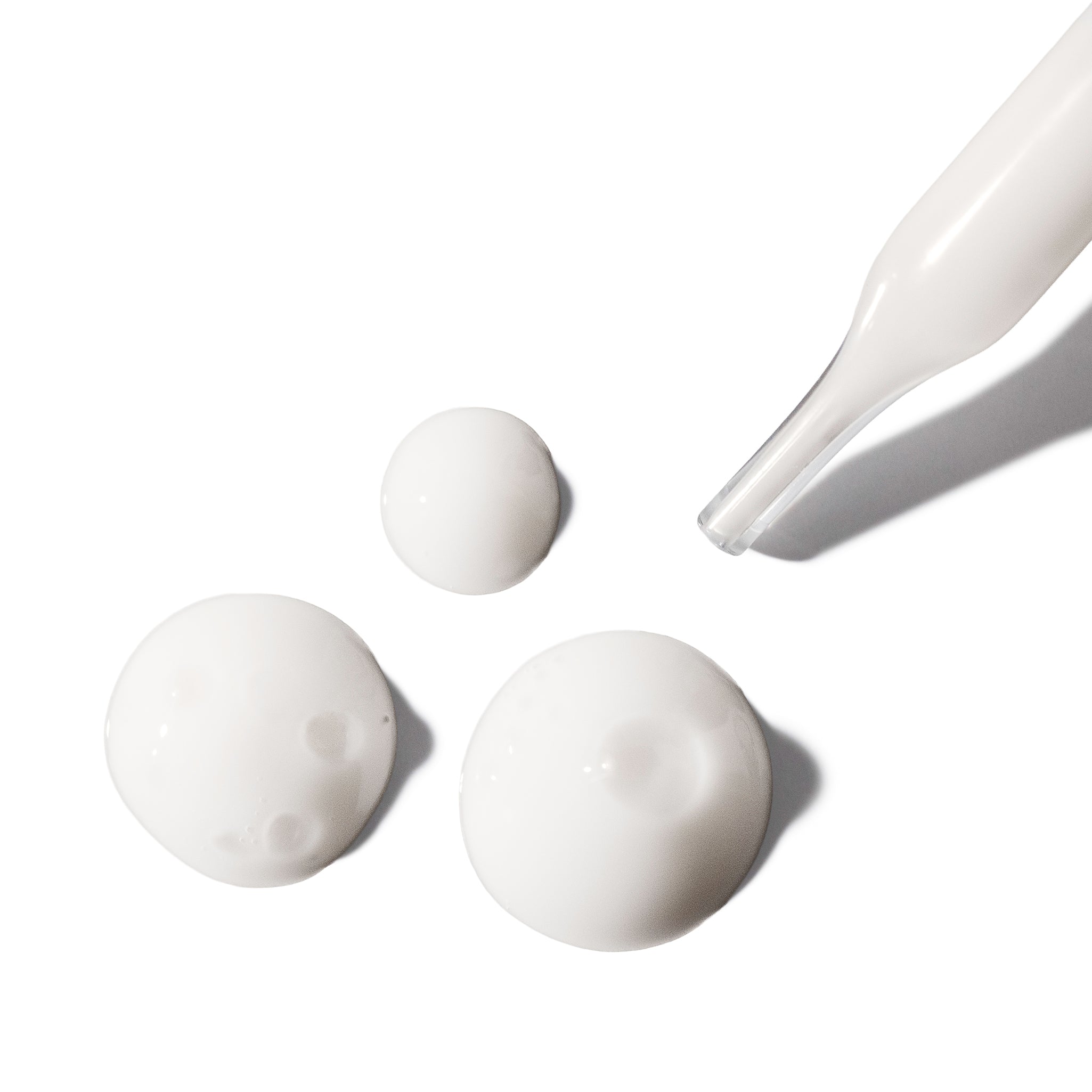 Indie Lee Vital Bloom Serum droplets on a white background