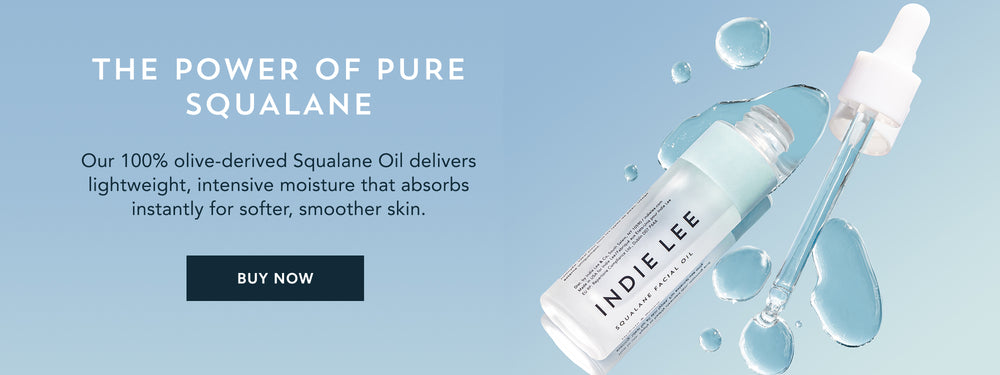 Open bottle of Indie Lee Squalane Facial Oil with drops of product dispensed from applicator
