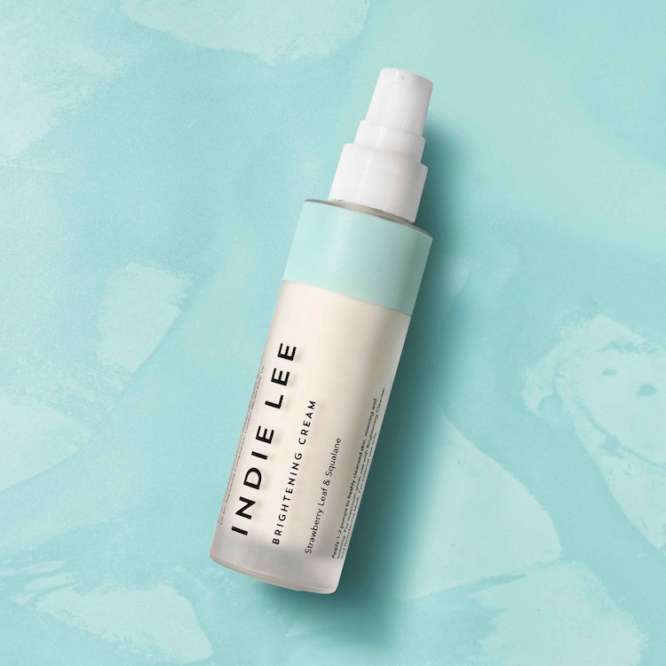 Indie Lee brightening cream bottle on a light blue background