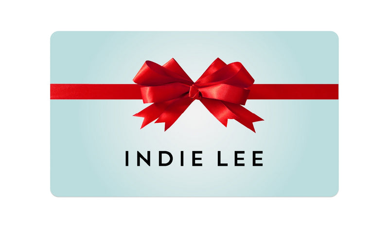 Gift card with a red bow and 'Indie Lee' branding on a light blue background